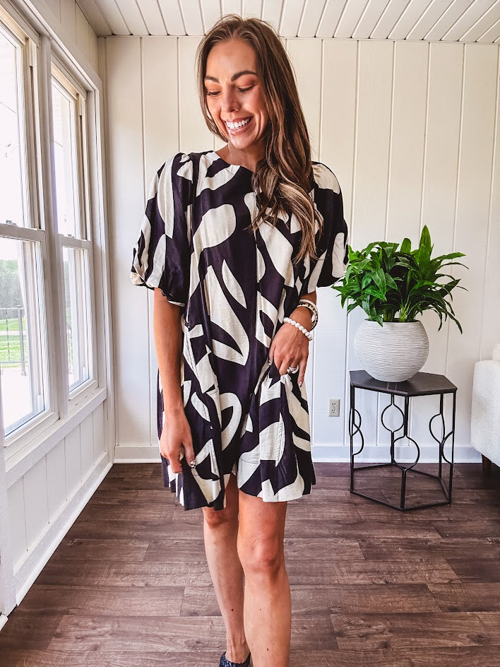 Short black and ivory abstract print dress, fully lined with hook and eye neck closure and puffed sleeves.