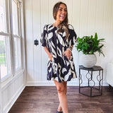 Short black and ivory abstract print dress, fully lined with hook and eye neck closure and puffed sleeves.