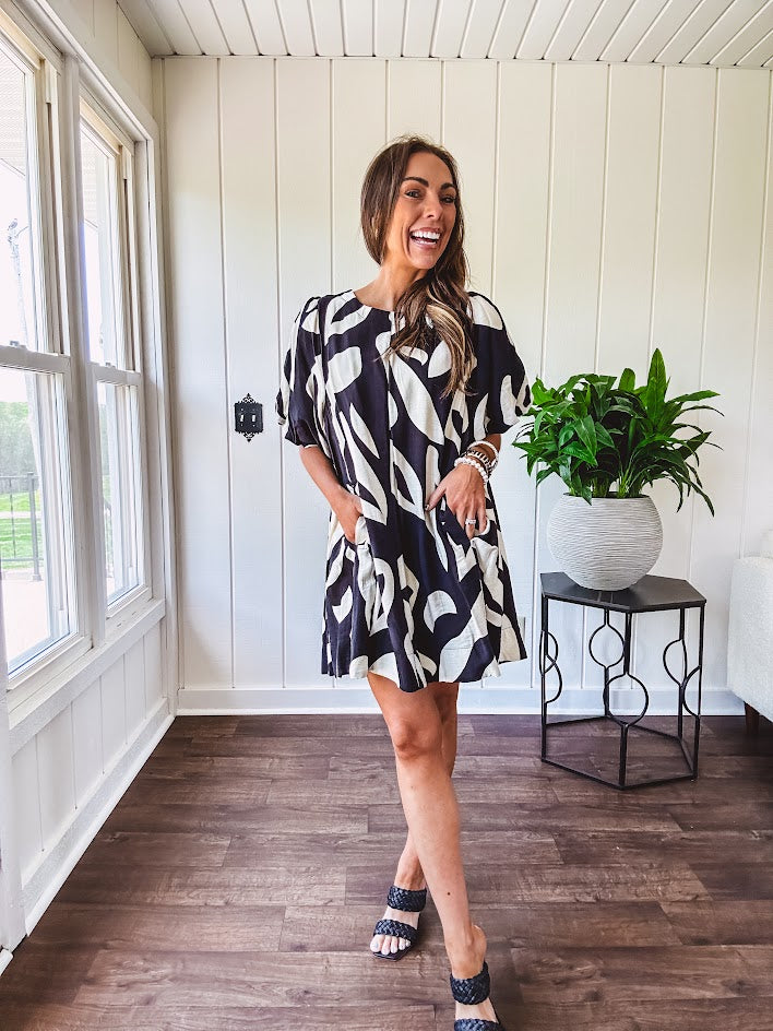 Short black and ivory abstract print dress, fully lined with hook and eye neck closure and puffed sleeves.