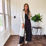Midi length ivory and small black polka dot long sleeved duster with silver buttons and pockets.