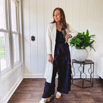 Midi length ivory and small black polka dot long sleeved duster with silver buttons and pockets.