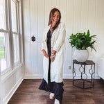 Midi length ivory and small black polka dot long sleeved duster with silver buttons and pockets.