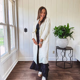 Midi length ivory and small black polka dot long sleeved duster with silver buttons and pockets.