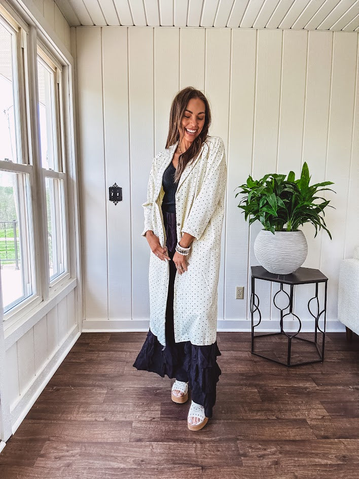Midi length ivory and small black polka dot long sleeved duster with silver buttons and pockets.