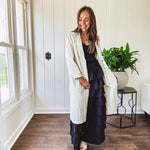 Midi length ivory and small black polka dot long sleeved duster with silver buttons and pockets.