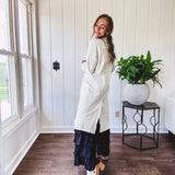 Midi length ivory and small black polka dot long sleeved duster with silver buttons and pockets.