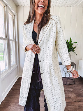 Midi length ivory and small black polka dot long sleeved duster with silver buttons and pockets.