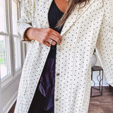 Midi length ivory and small black polka dot long sleeved duster with silver buttons and pockets.