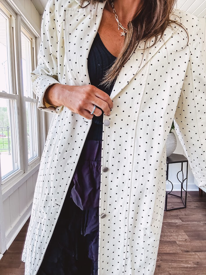 Midi length ivory and small black polka dot long sleeved duster with silver buttons and pockets.