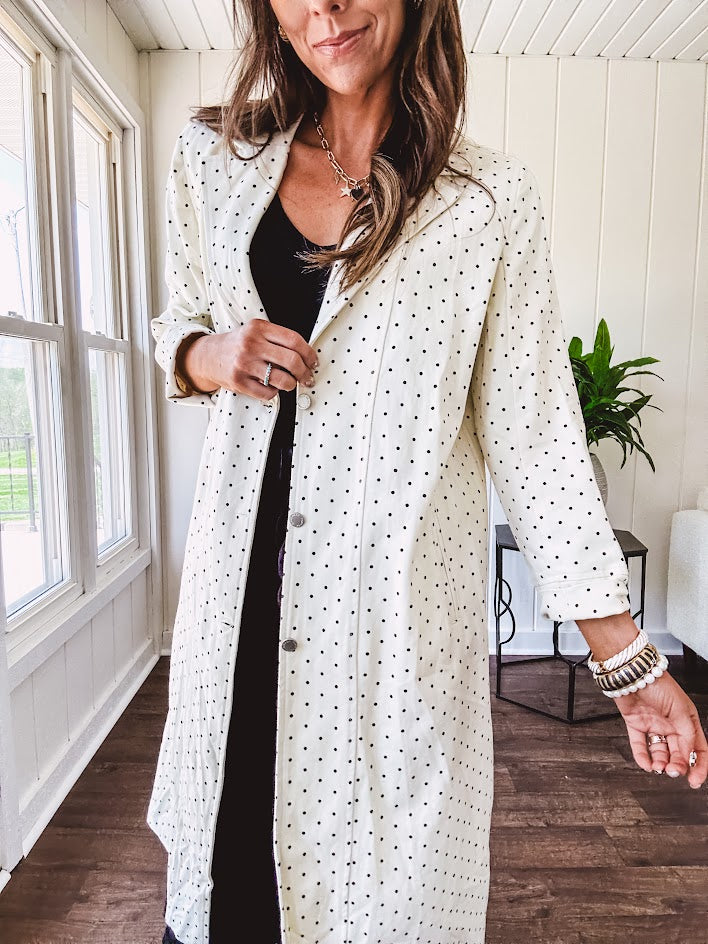 Midi length ivory and small black polka dot long sleeved duster with silver buttons and pockets.