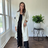Midi length ivory and small black polka dot long sleeved duster with silver buttons and pockets.