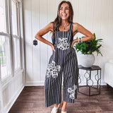 Thin, lightweight black and ivory striped overalls featuring black and ivory lace crochet patches throughout and faux wooden buttons at the adjustable straps and sides.