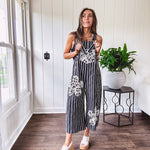 Thin, lightweight black and ivory striped overalls featuring black and ivory lace crochet patches throughout and faux wooden buttons at the adjustable straps and sides.