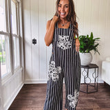 Thin, lightweight black and ivory striped overalls featuring black and ivory lace crochet patches throughout and faux wooden buttons at the adjustable straps and sides.