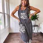 Thin, lightweight black and ivory striped overalls featuring black and ivory lace crochet patches throughout and faux wooden buttons at the adjustable straps and sides.