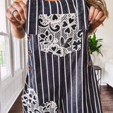 Thin, lightweight black and ivory striped overalls featuring black and ivory lace crochet patches throughout and faux wooden buttons at the adjustable straps and sides.