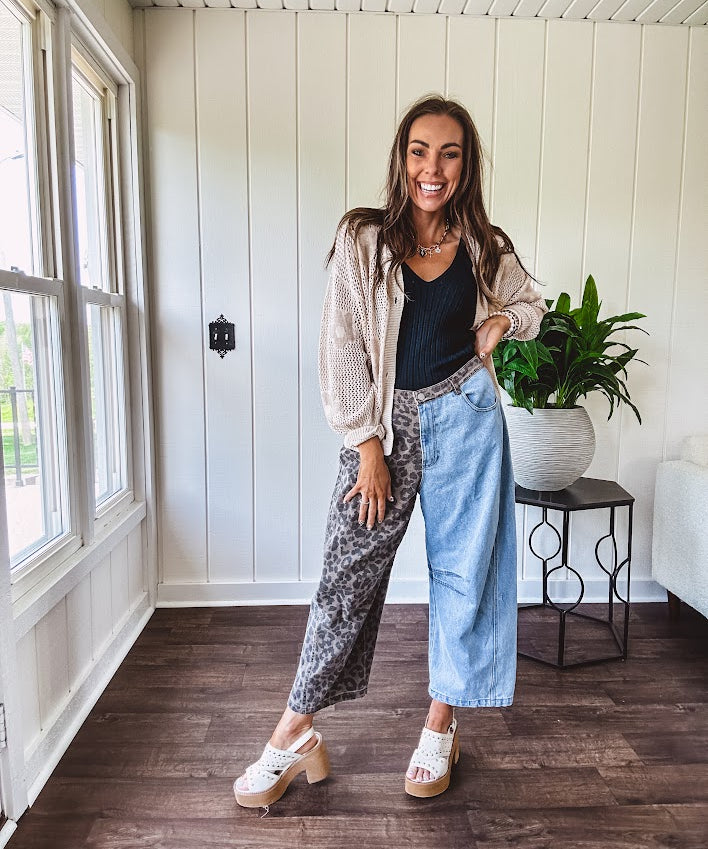 Denim barrel pants with one leg leo print and the other medium wash denim with elastic back waist and button and zipper closure.