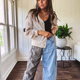 Denim barrel pants with one leg leo print and the other medium wash denim with elastic back waist and button and zipper closure.