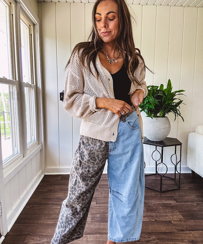 Denim barrel pants with one leg leo print and the other medium wash denim with elastic back waist and button and zipper closure.
