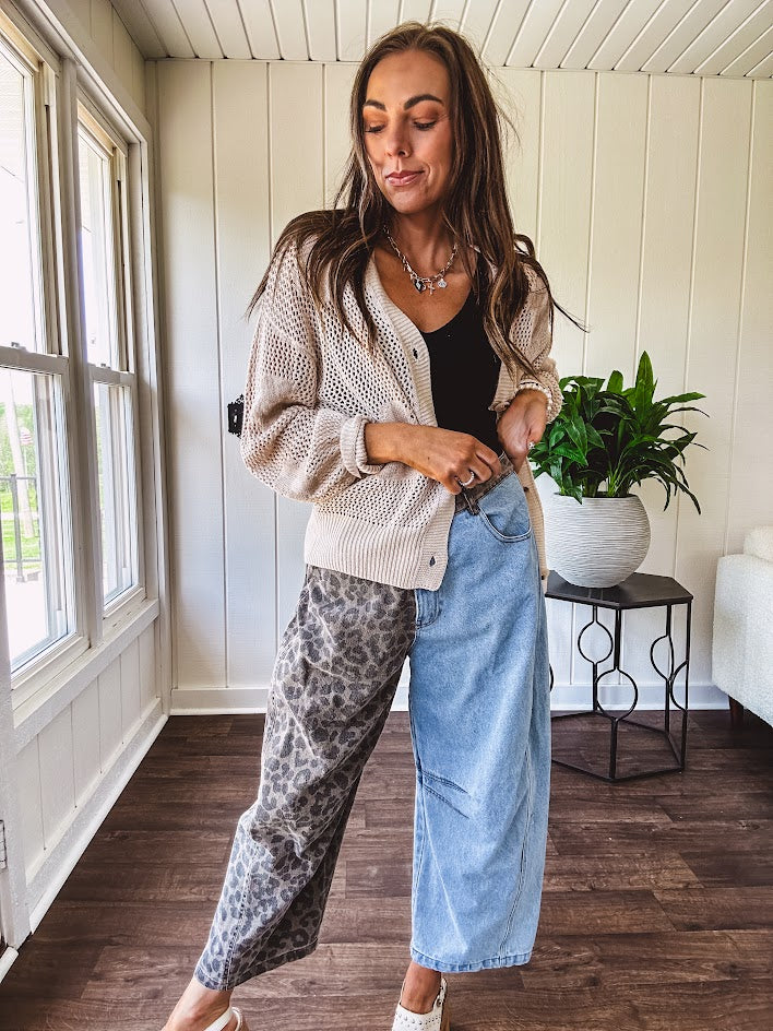 Denim barrel pants with one leg leo print and the other medium wash denim with elastic back waist and button and zipper closure.