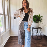 Denim barrel pants with one leg leo print and the other medium wash denim with elastic back waist and button and zipper closure.