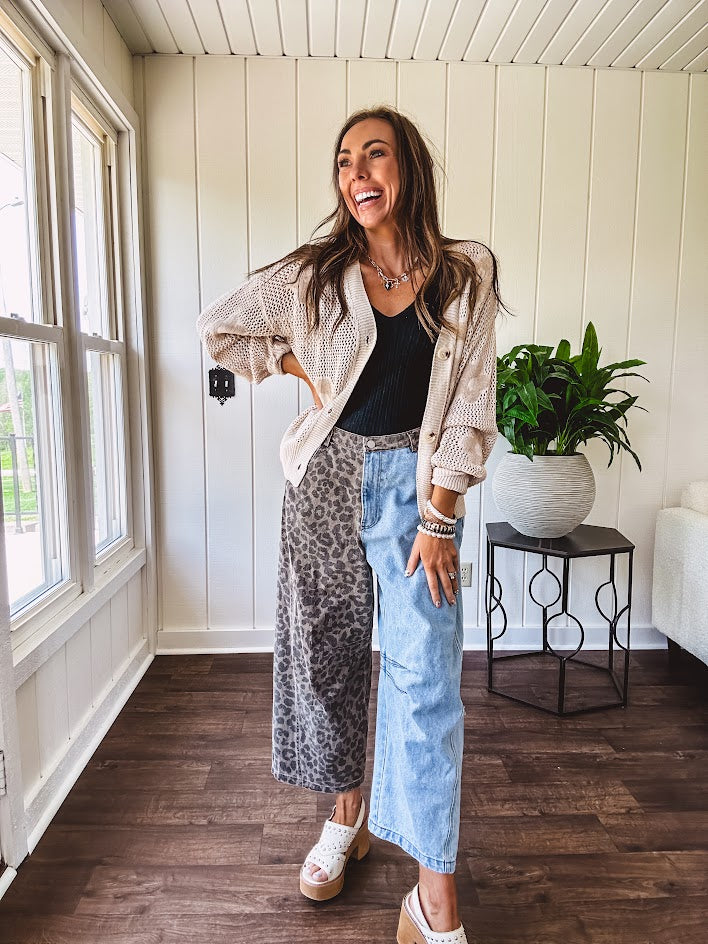 Denim barrel pants with one leg leo print and the other medium wash denim with elastic back waist and button and zipper closure.