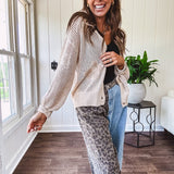 Oatmeal crochet short cardigan with long sleeves and floral motif with three faux wooden button closure.