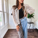 Oatmeal crochet short cardigan with long sleeves and floral motif with three faux wooden button closure.