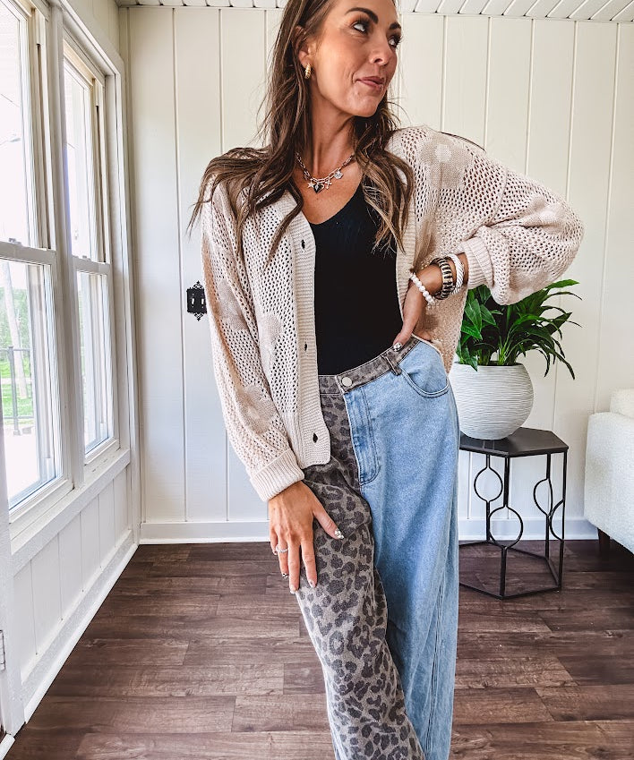 Oatmeal crochet short cardigan with long sleeves and floral motif with three faux wooden button closure.