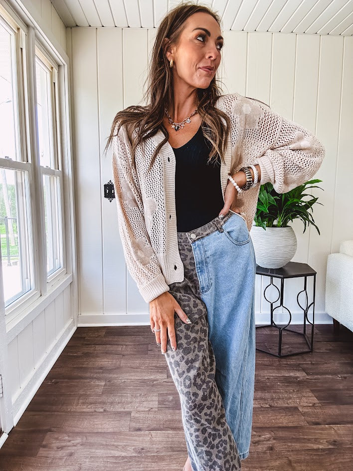Oatmeal crochet short cardigan with long sleeves and floral motif with three faux wooden button closure.