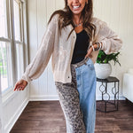 Oatmeal crochet short cardigan with long sleeves and floral motif with three faux wooden button closure.