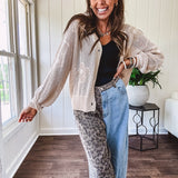 Oatmeal crochet short cardigan with long sleeves and floral motif with three faux wooden button closure.