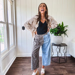 Denim barrel pants with one leg leo print and the other medium wash denim with elastic back waist and button and zipper closure.