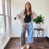 Denim barrel pants with one leg leo print and the other medium wash denim with elastic back waist and button and zipper closure.