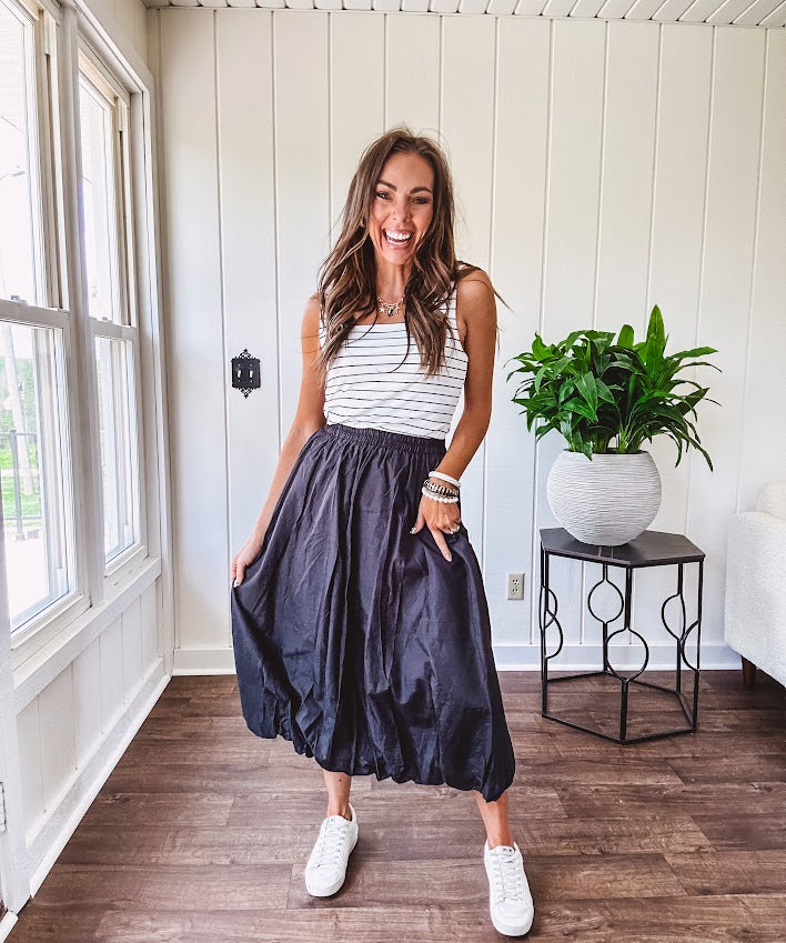 Midi length black athletic style bubble hem skirt with elastic waist and pockets.