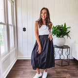 Midi length black athletic style bubble hem skirt with elastic waist and pockets.