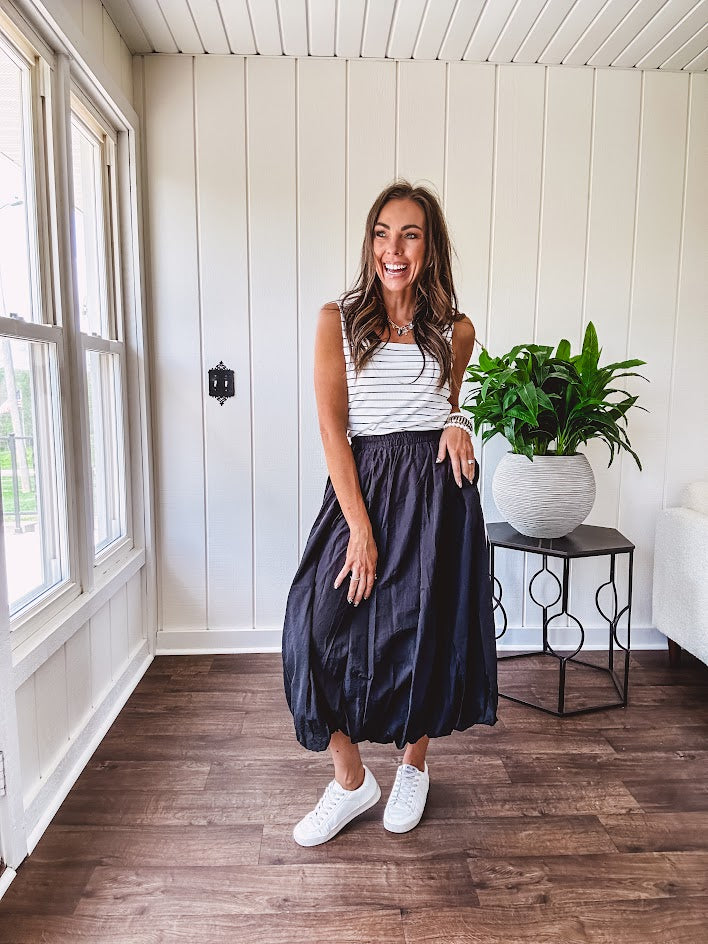 Midi length black athletic style bubble hem skirt with elastic waist and pockets.
