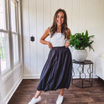 Midi length black athletic style bubble hem skirt with elastic waist and pockets.