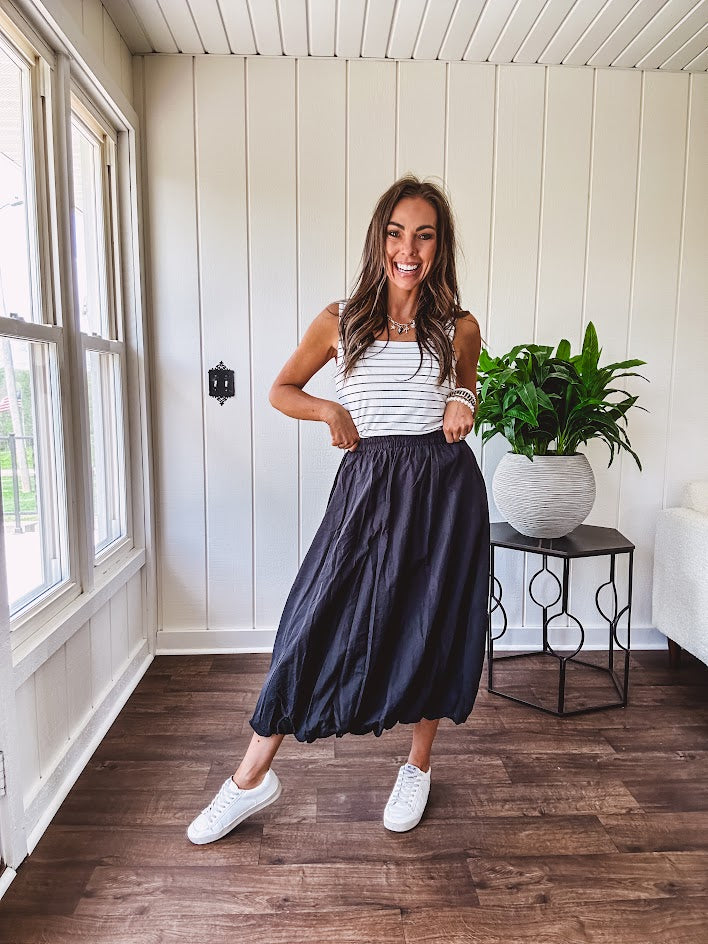 Midi length black athletic style bubble hem skirt with elastic waist and pockets.