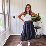 Midi length black athletic style bubble hem skirt with elastic waist and pockets.