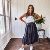 Midi length black athletic style bubble hem skirt with elastic waist and pockets.