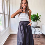 Midi length black athletic style bubble hem skirt with elastic waist and pockets.