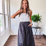 Midi length black athletic style bubble hem skirt with elastic waist and pockets.