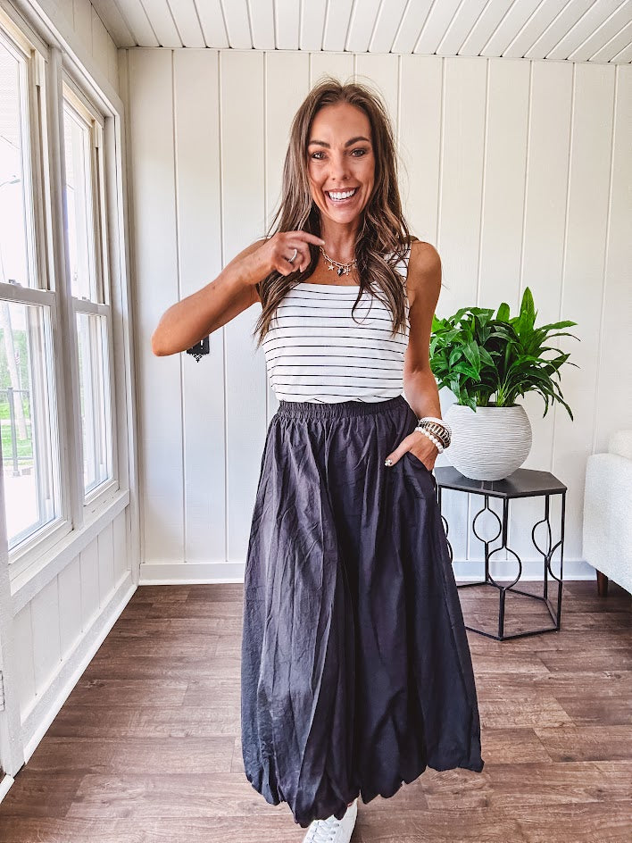 Midi length black athletic style bubble hem skirt with elastic waist and pockets.