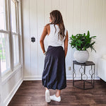 Midi length black athletic style bubble hem skirt with elastic waist and pockets.