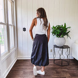 Midi length black athletic style bubble hem skirt with elastic waist and pockets.