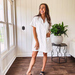 Lined cream denim-like short shift dress with V neck and collar, short sleeves,, contrasting tan stitching, front pocket and eyelet details throughout