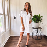 Lined cream denim-like short shift dress with V neck and collar, short sleeves,, contrasting tan stitching, front pocket and eyelet details throughout
