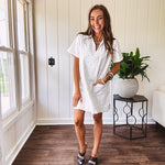 Lined cream denim-like short shift dress with V neck and collar, short sleeves,, contrasting tan stitching, front pocket and eyelet details throughout