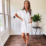Lined cream denim-like short shift dress with V neck and collar, short sleeves,, contrasting tan stitching, front pocket and eyelet details throughout